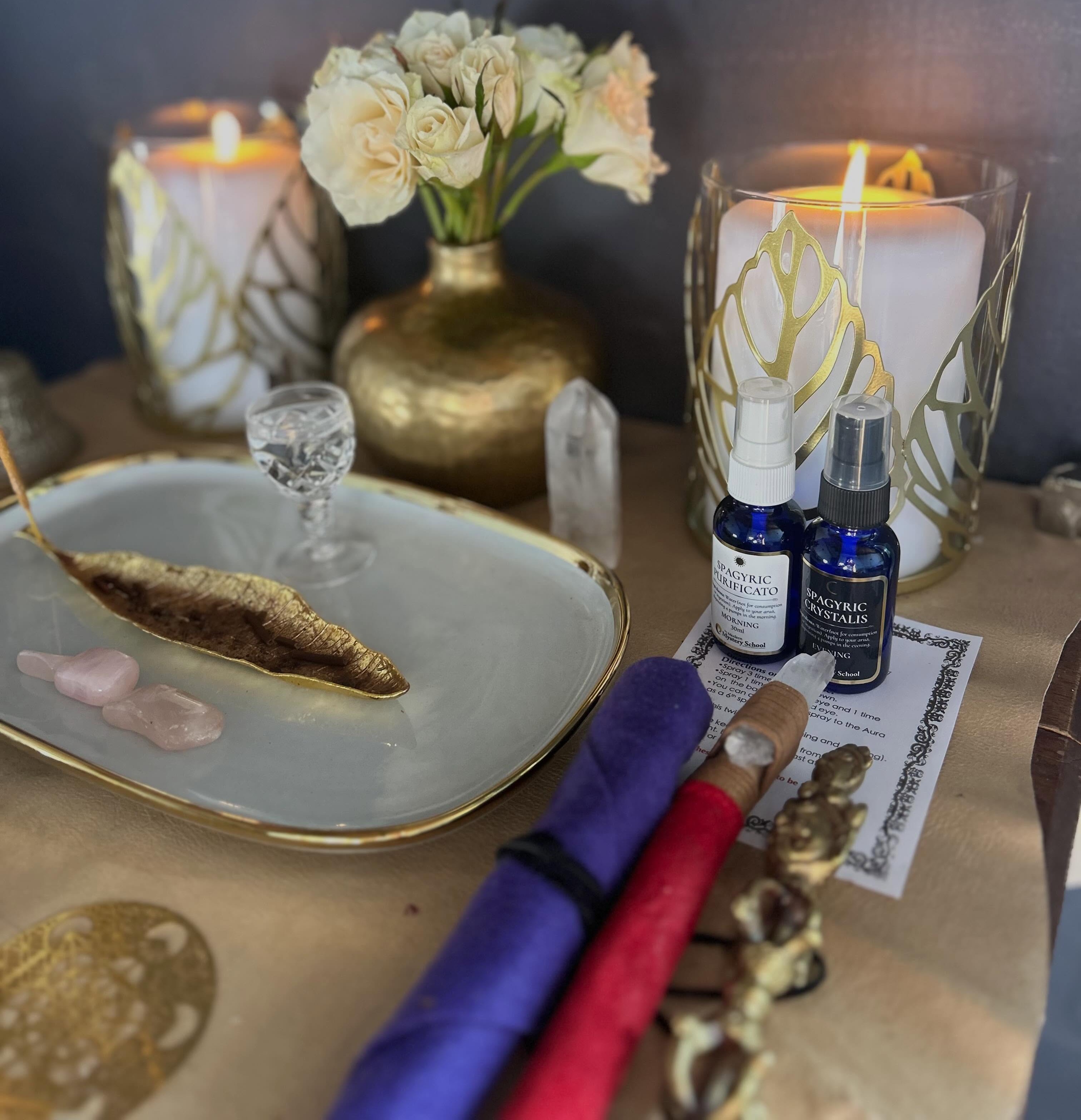 Spagyric Purificado and Crystalis bottles on an altar with candles and crystals
